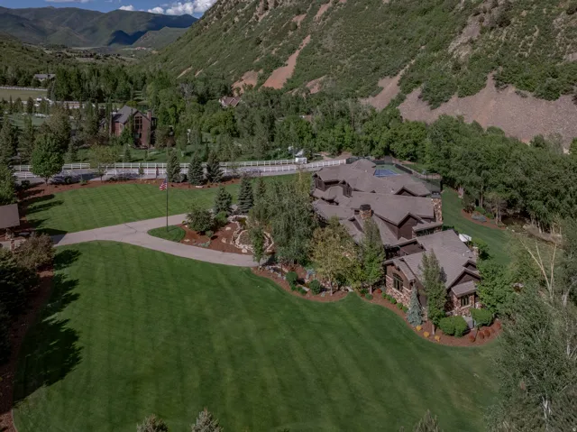 Extensive estate featuring a multi-level main residence with stone and wood siding details, gabled rooflines, and multiple skylights