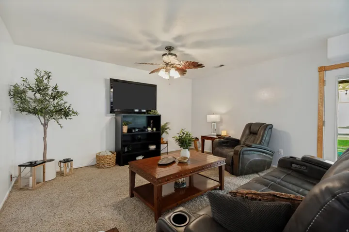 Recessed lighting, ceiling fan light fixture, wood-finish door frame, mounted television, and built-in shelving