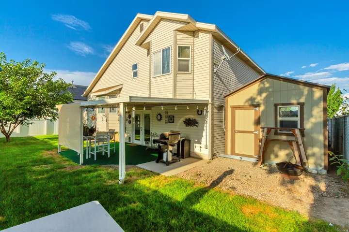 Exterior featuring a covered patio, a detached storage shed, and a fenced yard with mature landscaping