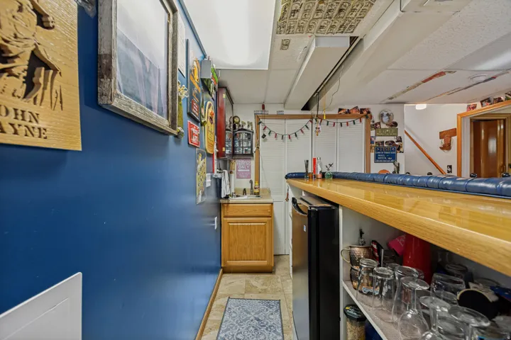 Built-in bar with wood-finish countertop, under-counter shelving, and integrated sink