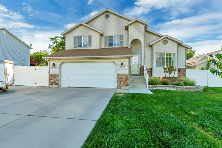 Two-story residence featuring a two-car garage, stone accents, and a concrete driveway