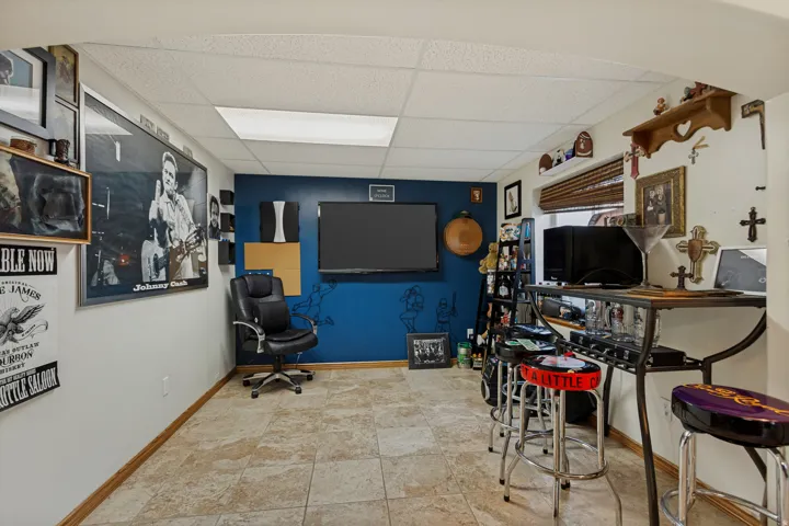 Recessed lighting, tile flooring, accent wall, built-in shelving, and window with blinds