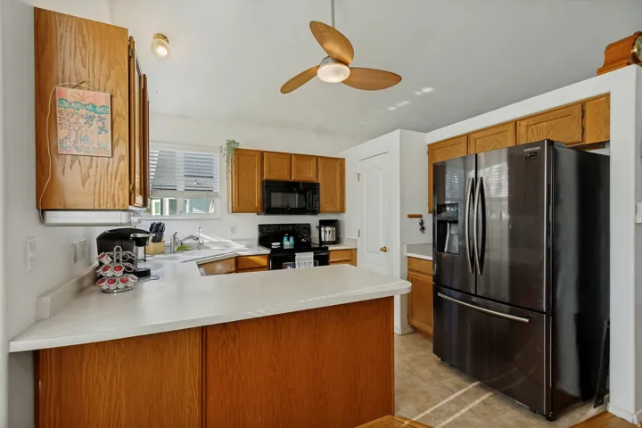 Kitchen featuring wood-finish cabinetry, solid surface countertops, and a window above the sink