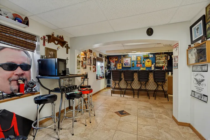 Archway entry into a dedicated bar area with a built-in counter and bar stools
