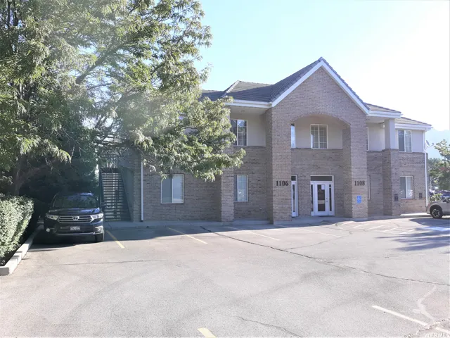 Brick exterior with light-colored siding accents, pitched roofline, and multiple windows