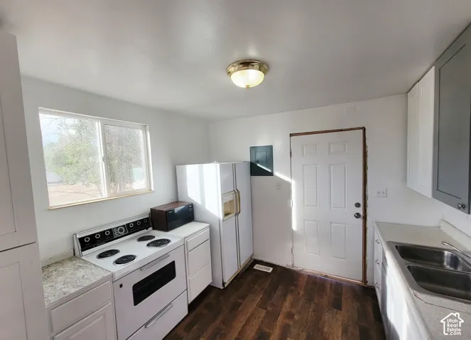 White paneled cabinetry with contrasting grey upper cabinets, stainless steel double basin sink, wood-finish flooring, and a flush mount ceiling light