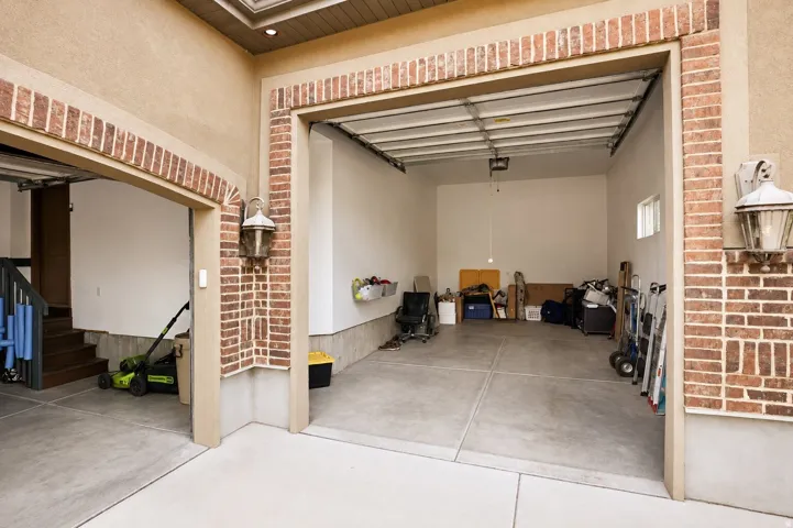 Two-car garage with brick detailing and stucco exterior