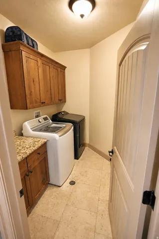 Built-in wood cabinetry, a granite-look countertop, and neutral-toned tile flooring