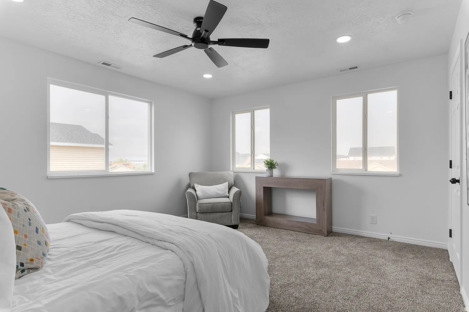 Recessed lighting, ceiling fan, three windows, and carpeted flooring