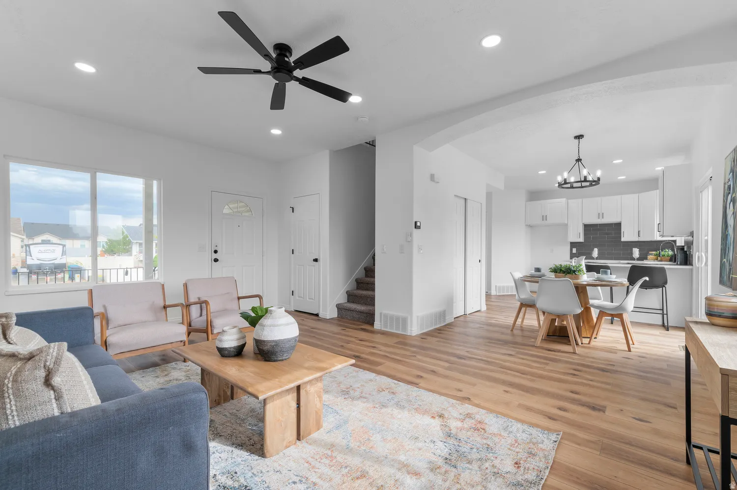 Open-concept living area featuring wood-finish flooring, recessed lighting, and a modern ceiling fan