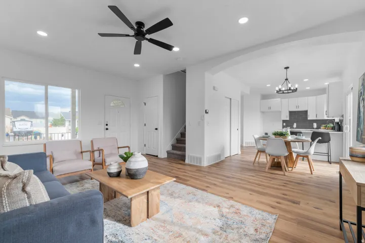 Open-concept living area featuring wood-finish flooring, recessed lighting, and a modern ceiling fan