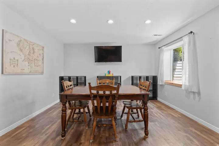 Recessed lighting, wood-finish flooring, and a window with a wood sill
