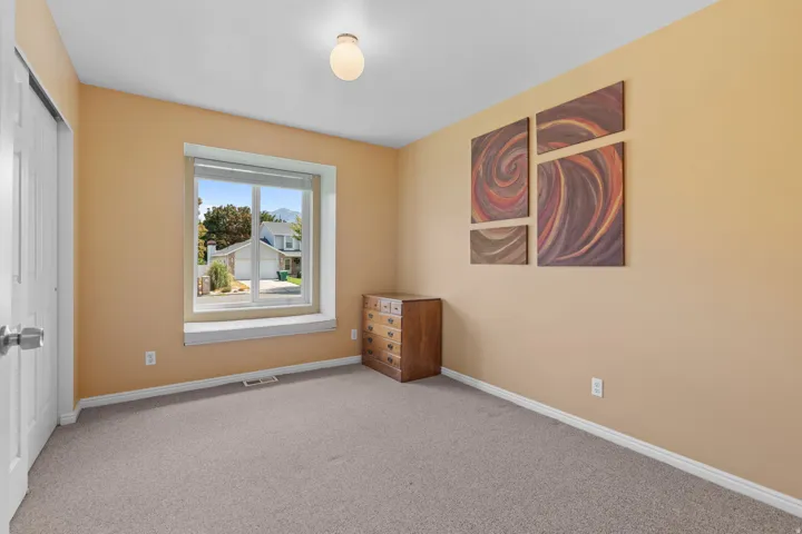 Carpeted flooring, neutral wall finish, white trim, overhead light fixture, and a window with blinds