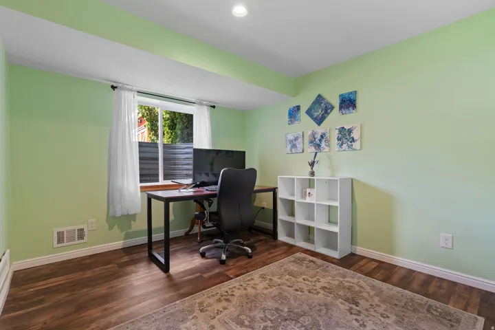 Wood-finish flooring, recessed lighting, and a white trim window
