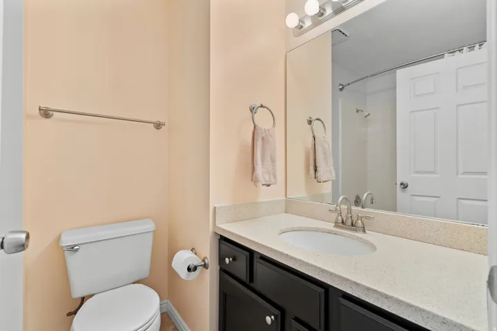 Vanity with a light-toned countertop, under-mount sink, and dark wood-finish cabinetry