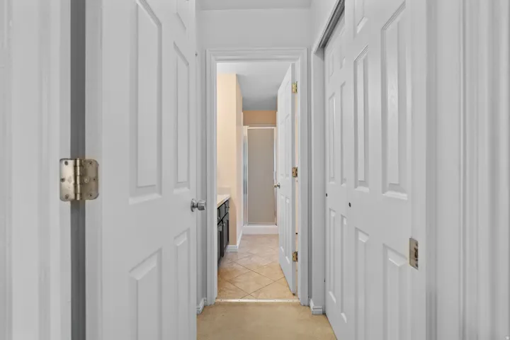 Hallway with white paneled doors and carpet flooring