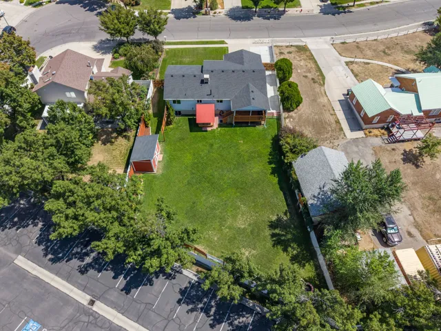 Expansive rear yard featuring a green lawn, wood deck, and detached storage shed