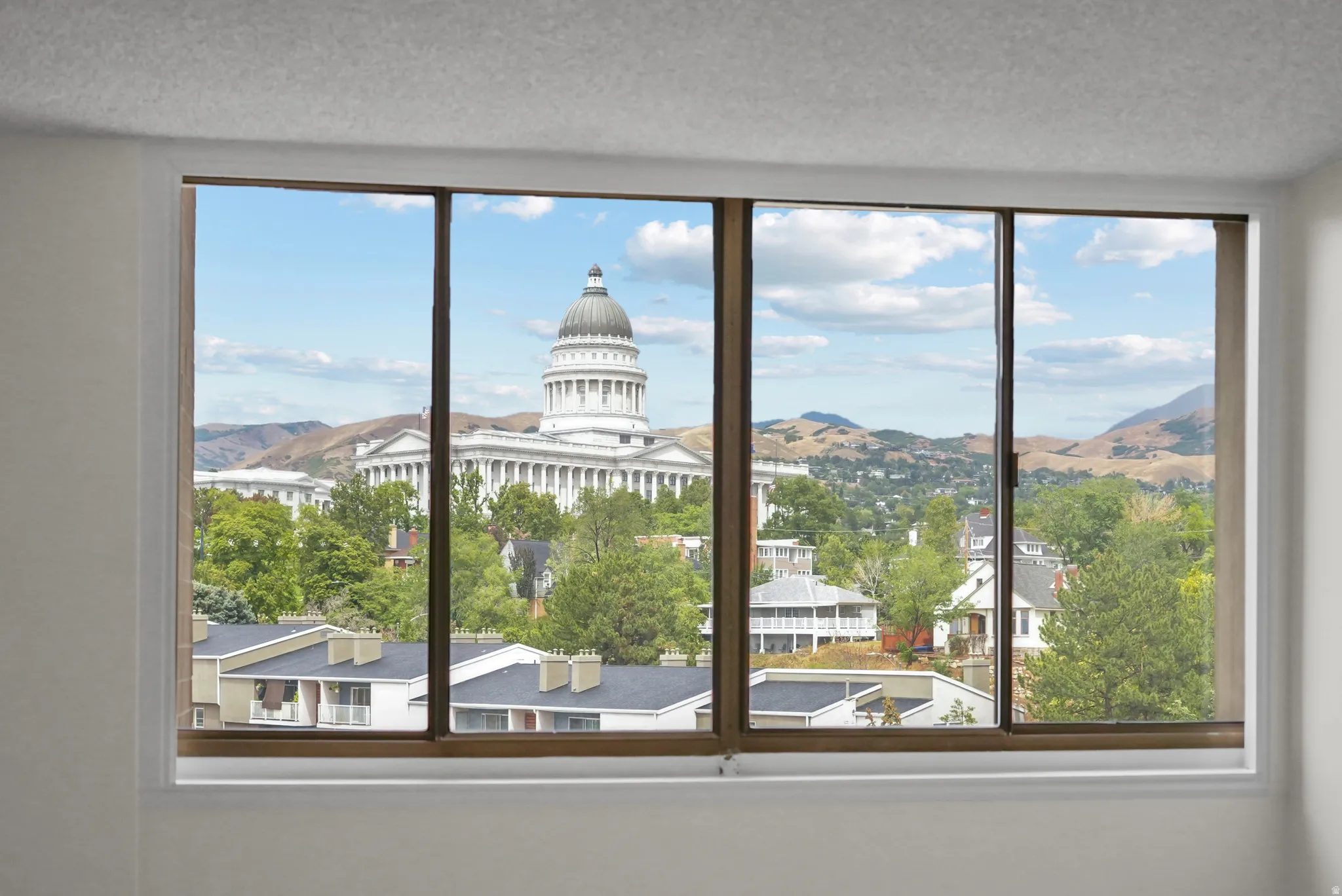 Expansive window offering a sweeping urban and mountain backdrop