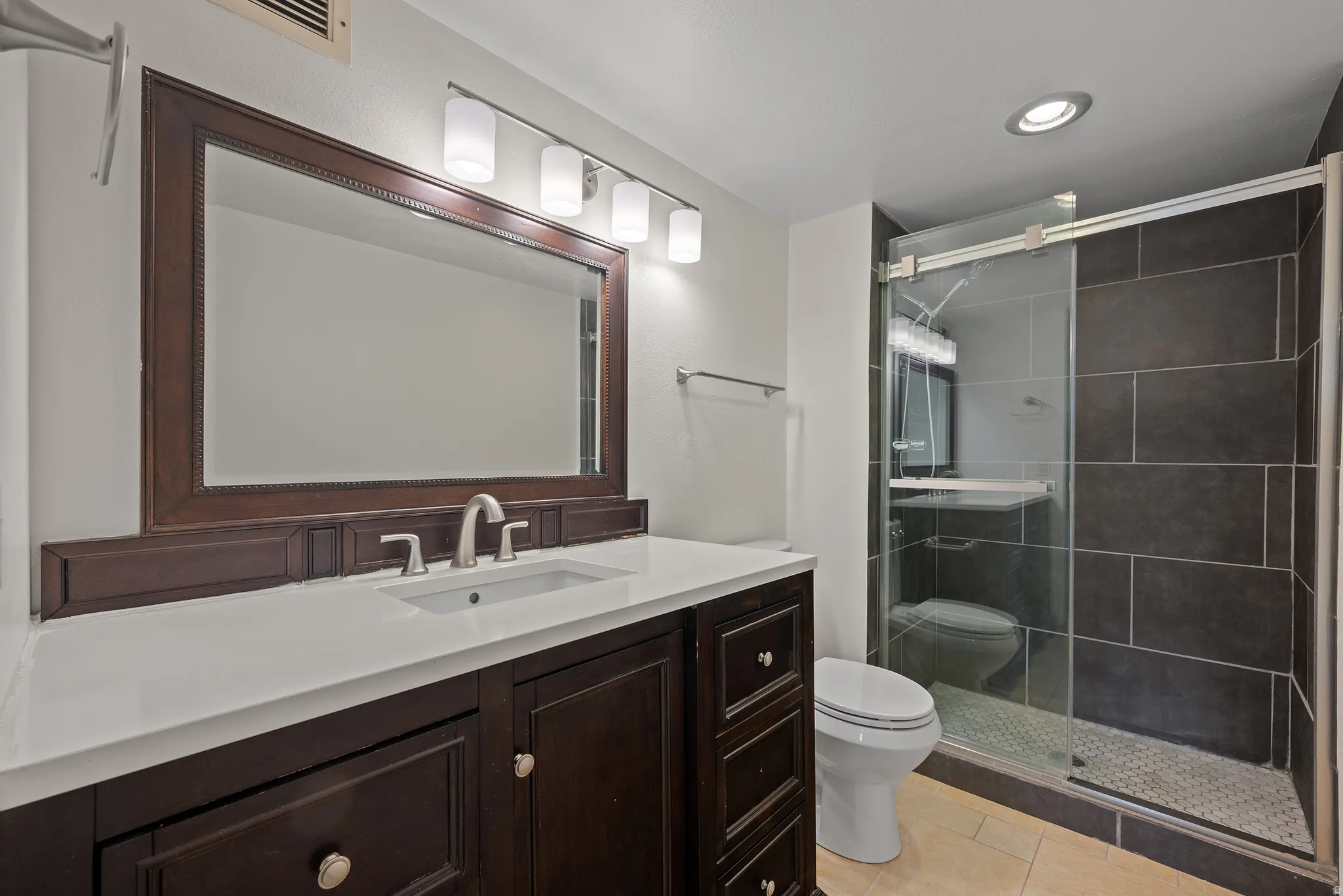 Dark wood-finish vanity with a white countertop and undermount sink