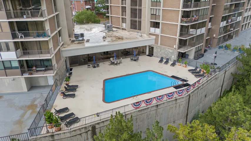 Community pool with concrete decking and adjacent patio space