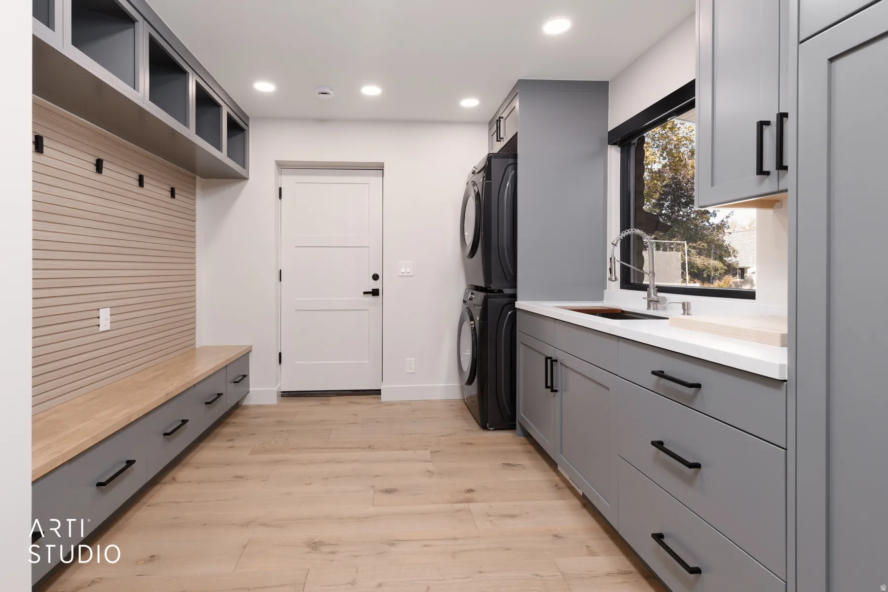 Built-in storage bench with drawers, wall-mounted hooks, and overhead shelving