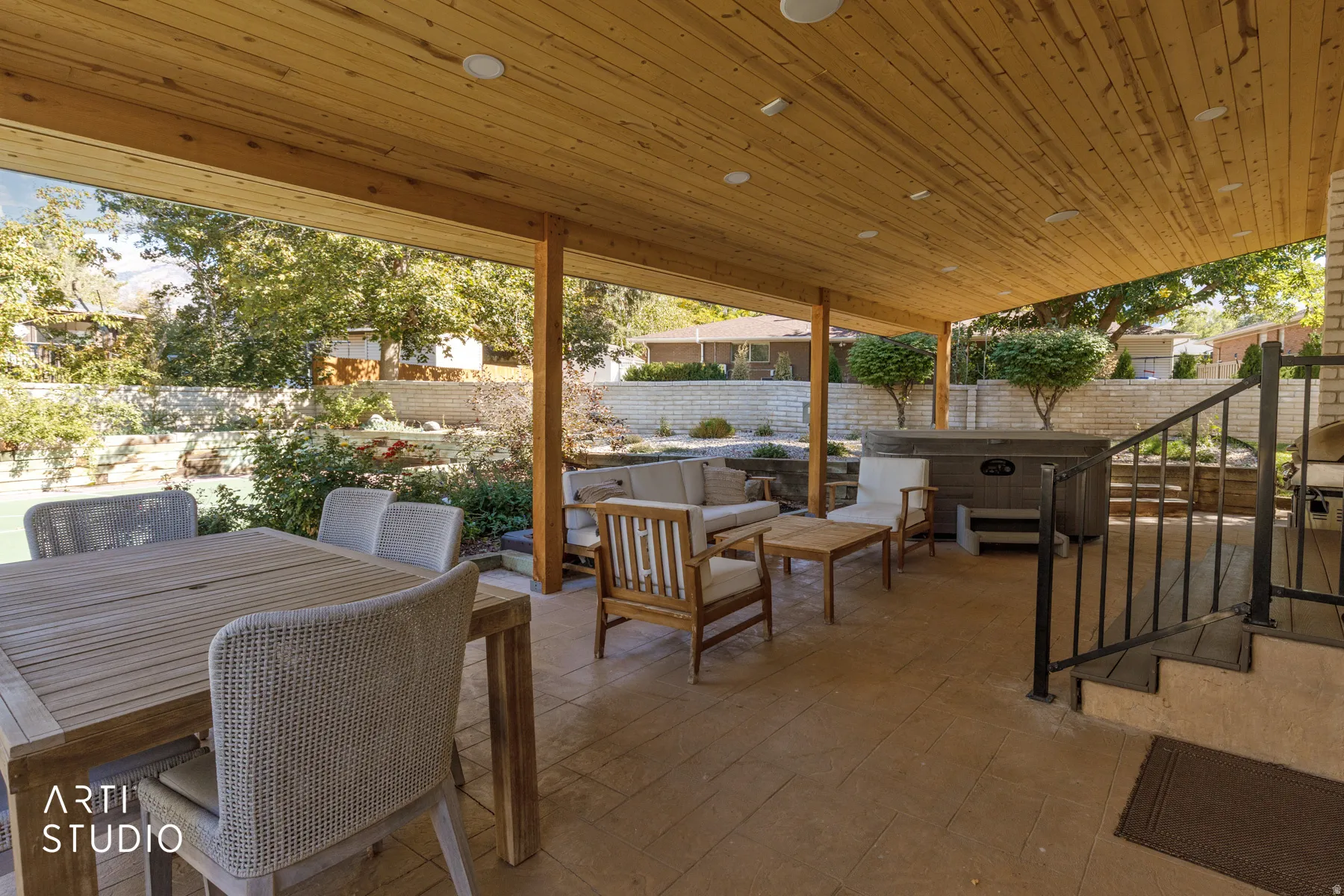 Covered outdoor living space featuring a wood-panel ceiling with recessed lighting