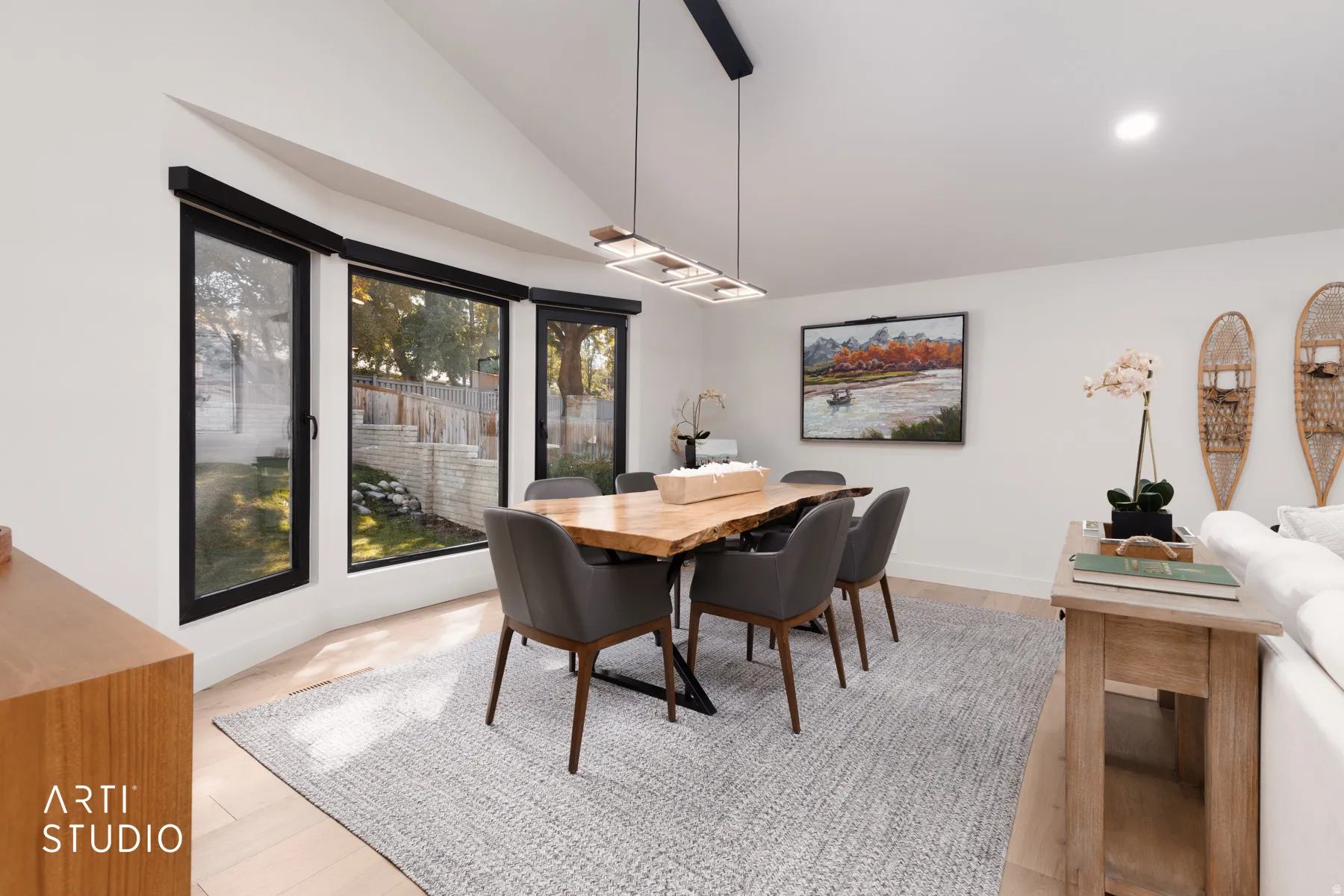 Vaulted ceiling, recessed lighting, wood-finish flooring, black-framed windows, contemporary pendant lighting