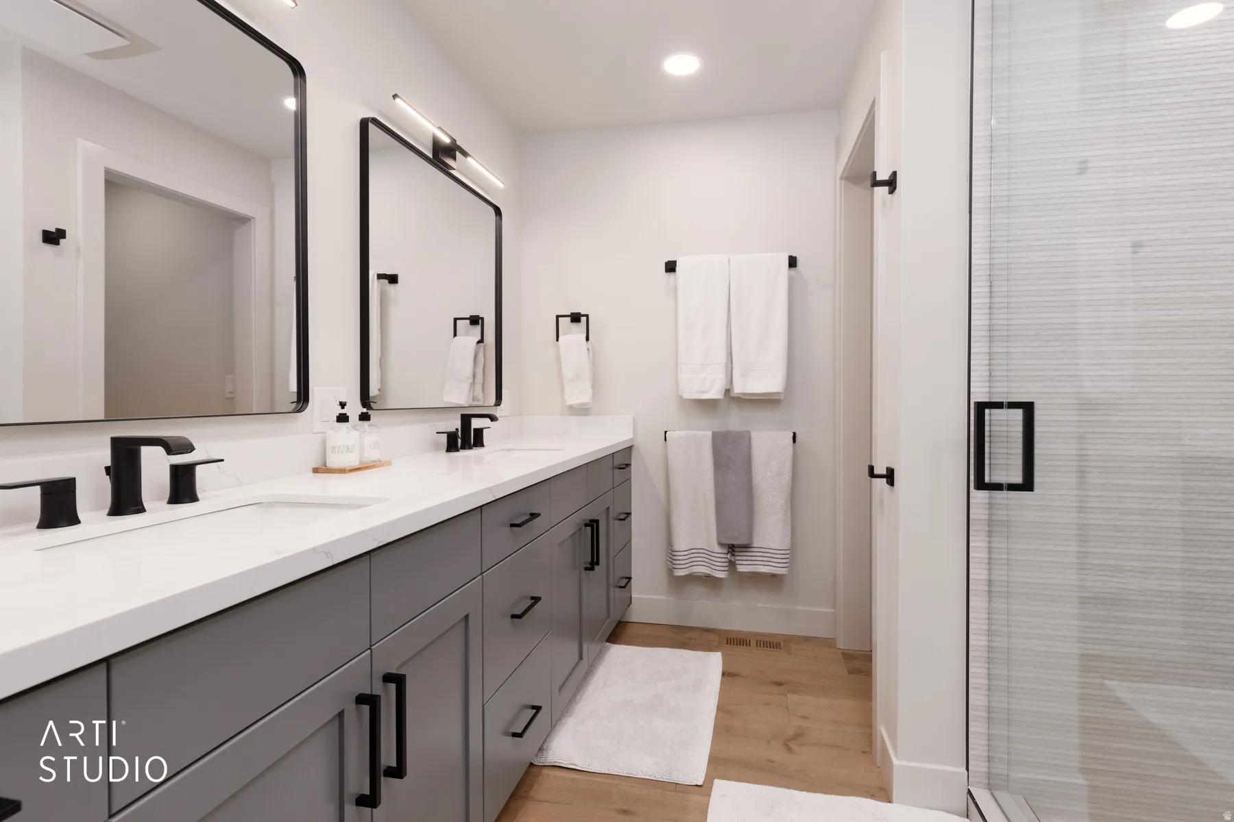 Dual vanity with white countertops, undermount sinks, and matte black fixtures