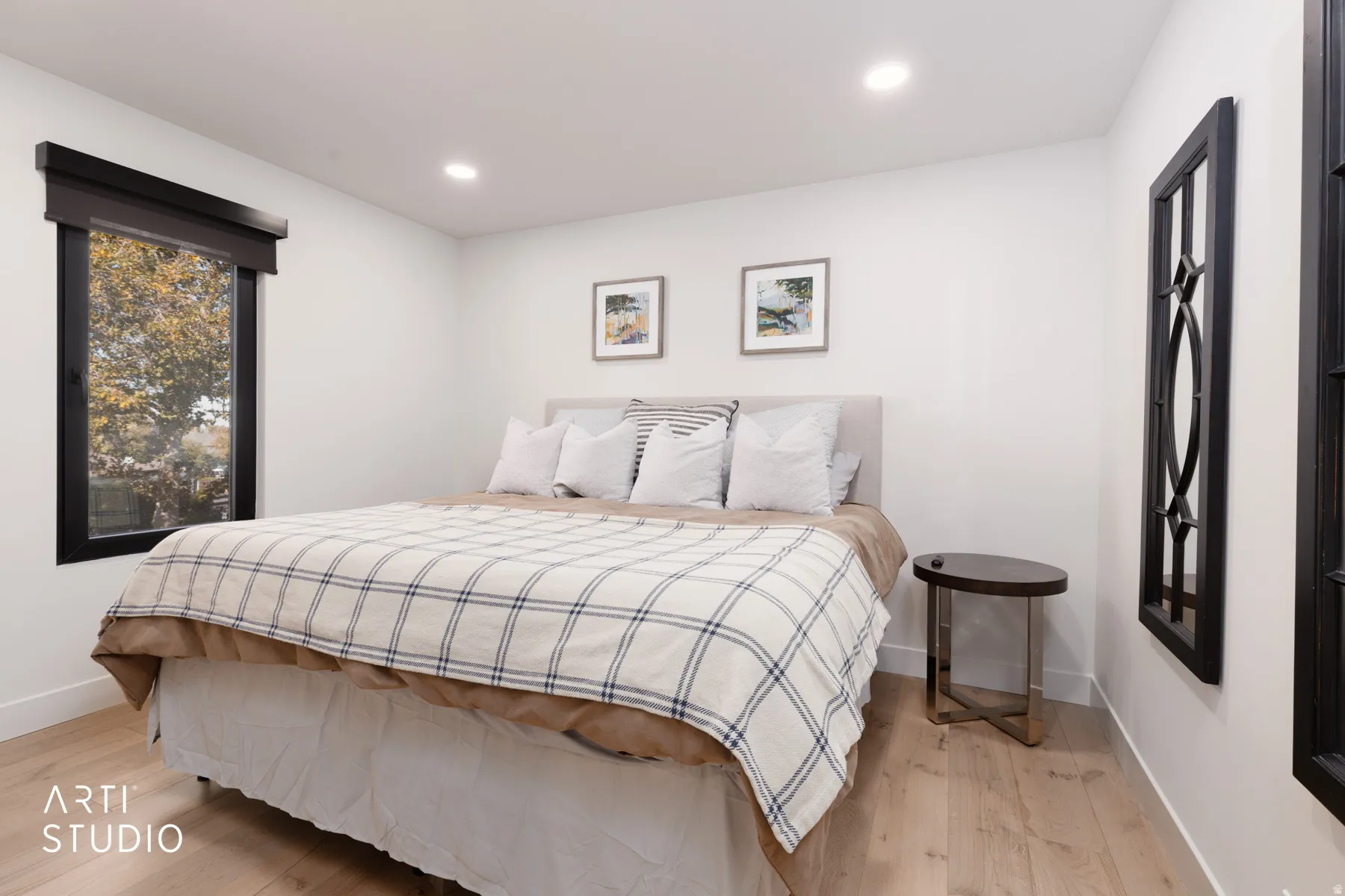 Recessed ceiling lighting, wood-finish flooring, and a large window with dark trim