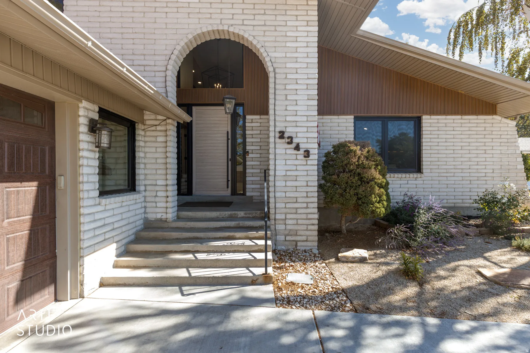 White brick exterior with an arched entryway