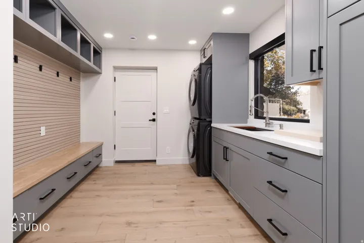 Built-in storage bench with drawers, wall-mounted hooks, and overhead shelving