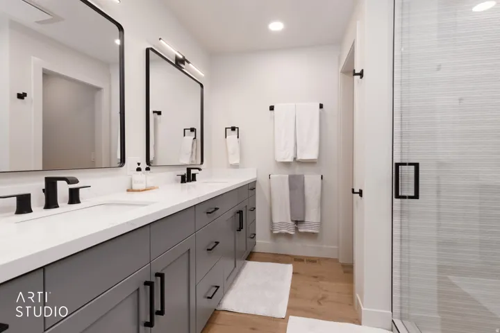Dual vanity with white countertops, undermount sinks, and matte black fixtures
