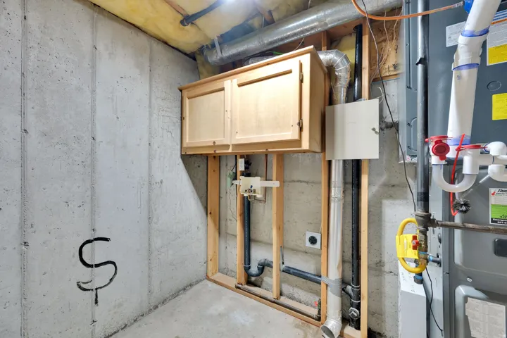 Finished concrete flooring, concrete walls, exposed ductwork, wood-finish cabinetry, and exposed structural framing