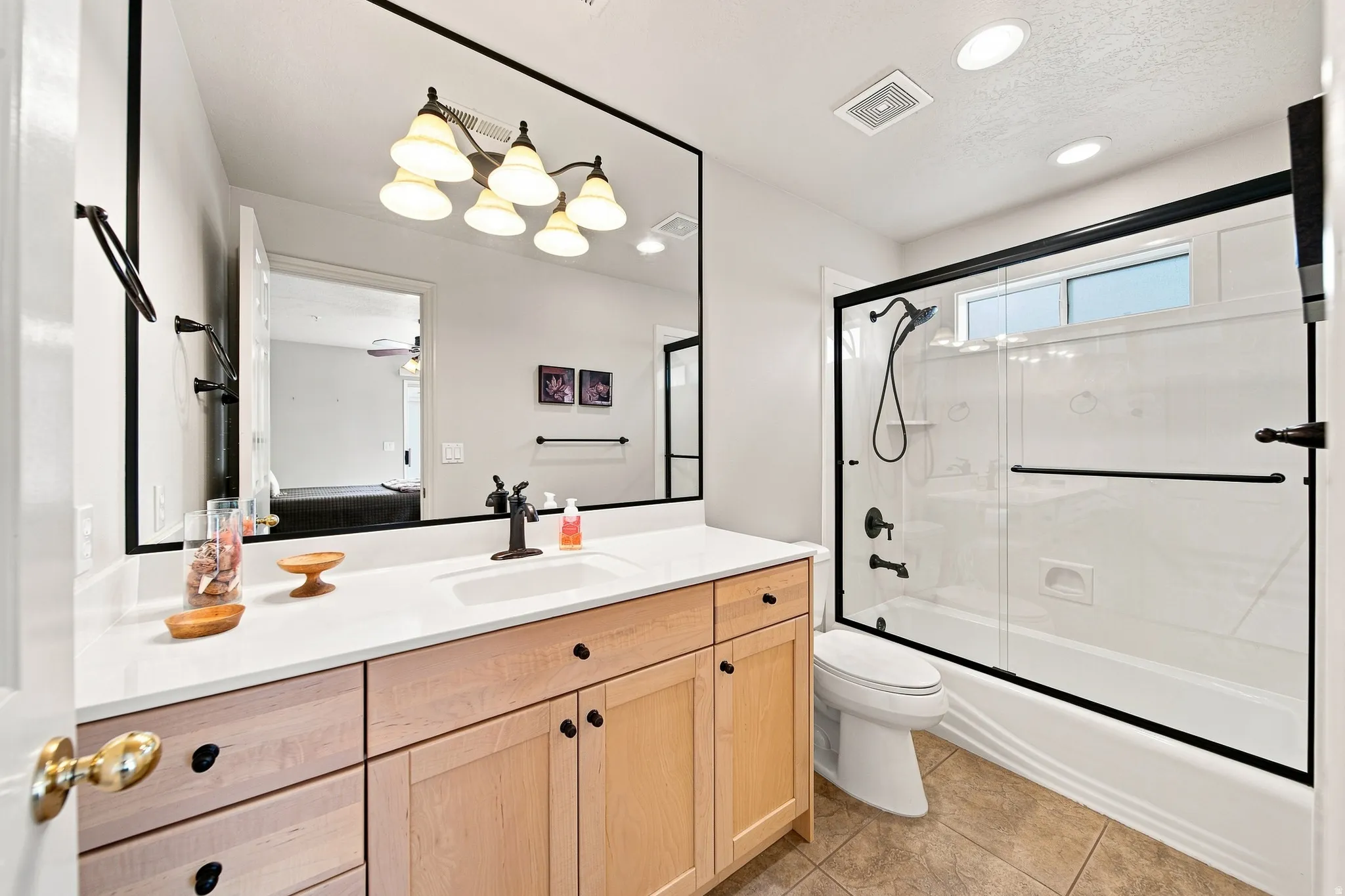 Vanity with a single basin, light wood cabinetry, and a light-toned countertop