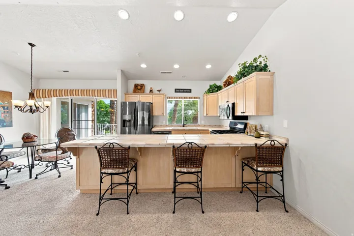Kitchen featuring light wood-finish cabinetry, tile countertops, and recessed lighting