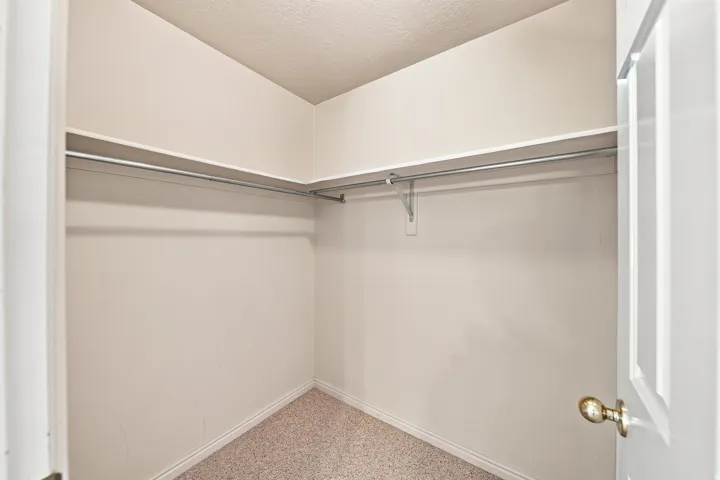 Wall-to-wall carpeting and built-in shelving with hanging rods