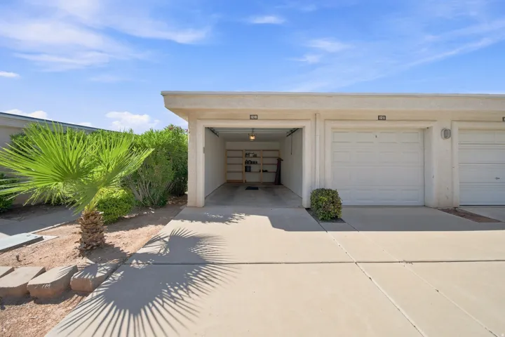 Attached multi-car garage with overhead lighting and a concrete drive