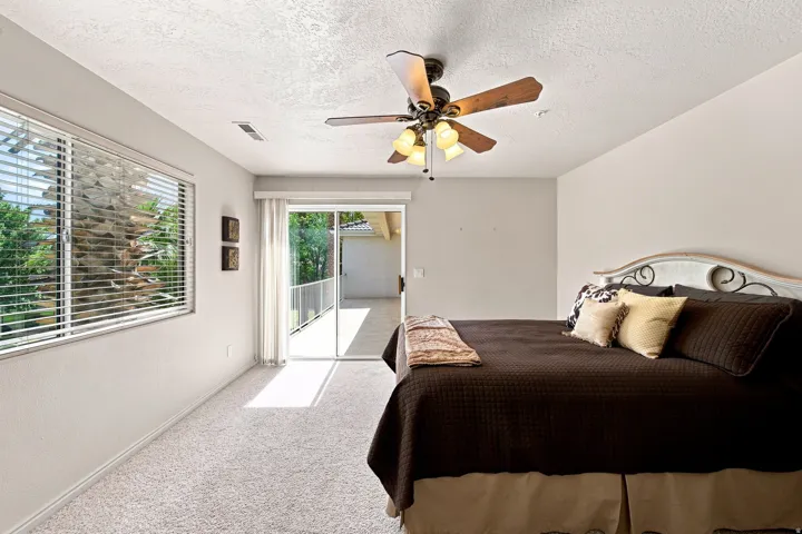 Recessed lighting, ceiling fan with light fixture, sliding glass door, private balcony, and carpeted flooring