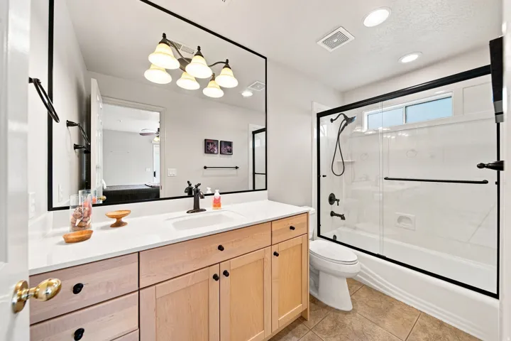 Vanity with a single basin, light wood cabinetry, and a light-toned countertop
