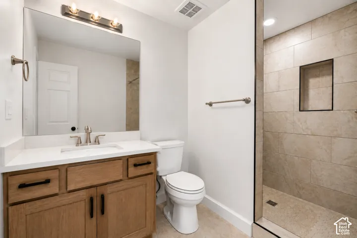 Modern bathroom featuring a wood-finish vanity with a white countertop and rectangular sink, brushed nickel faucet, and a large frameless mirror
