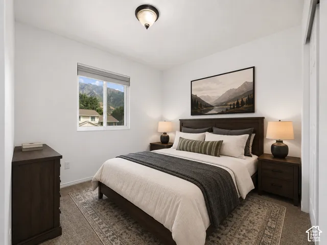 Window with mountain backdrop, flush-mount ceiling light fixture, wood-finish flooring, wood-finish bedroom furniture, and white interior walls