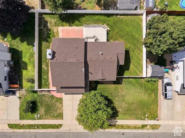 Aerial view showcasing a dual-structure home with distinctive peaked rooflines and dark composite shingles