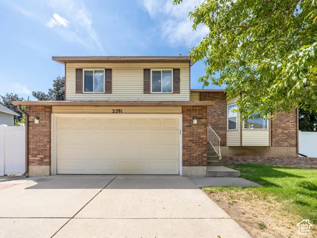 Brick exterior with siding accents, attached two-car garage, and concrete driveway
