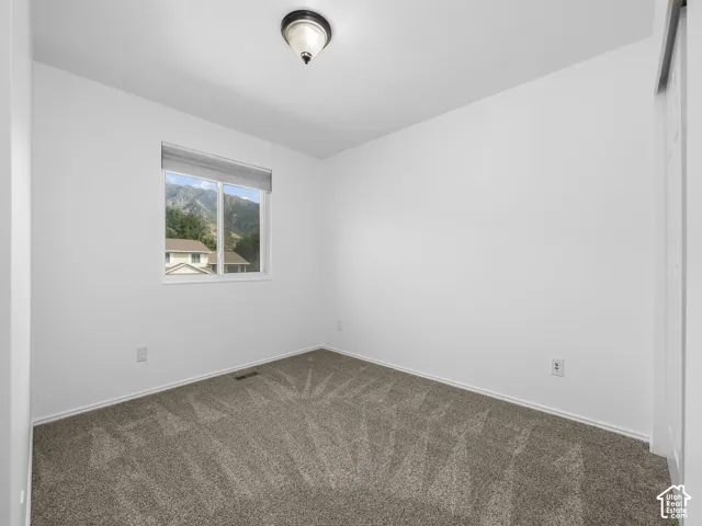 Recessed window with mountain backdrop, neutral carpeting, white walls, and a ceiling-mounted light fixture