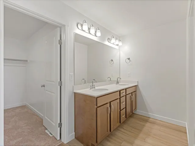 Dual vanity featuring undermount sinks and chrome faucets