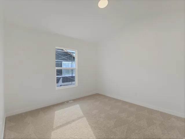 Neutral tone wall paint, neutral tone carpeting, single window, white trim, ceiling light fixture
