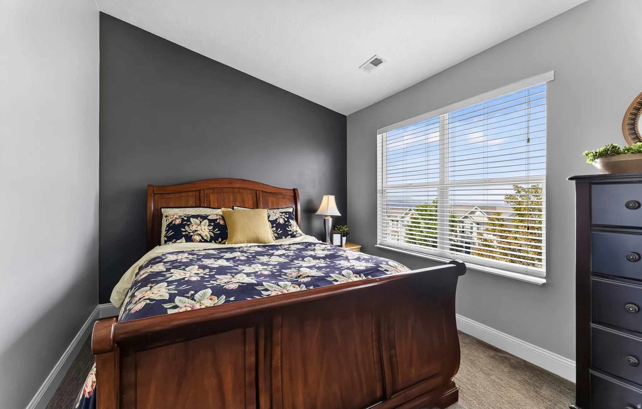 Wood-finish flooring, accent wall, and a large window with blinds
