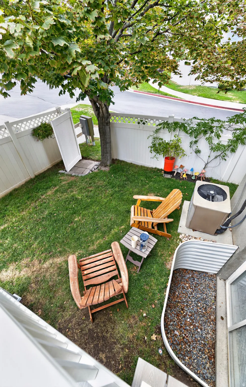 Fenced backyard with established tree and green lawn
