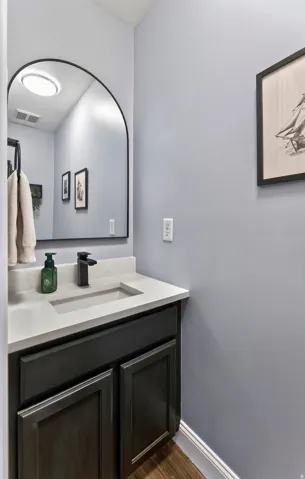 Vanity with a light-colored countertop, integrated rectangular sink, and matte black faucet