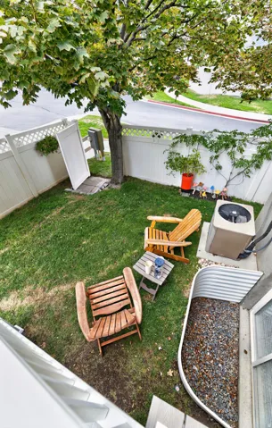 Fenced backyard with established tree and green lawn